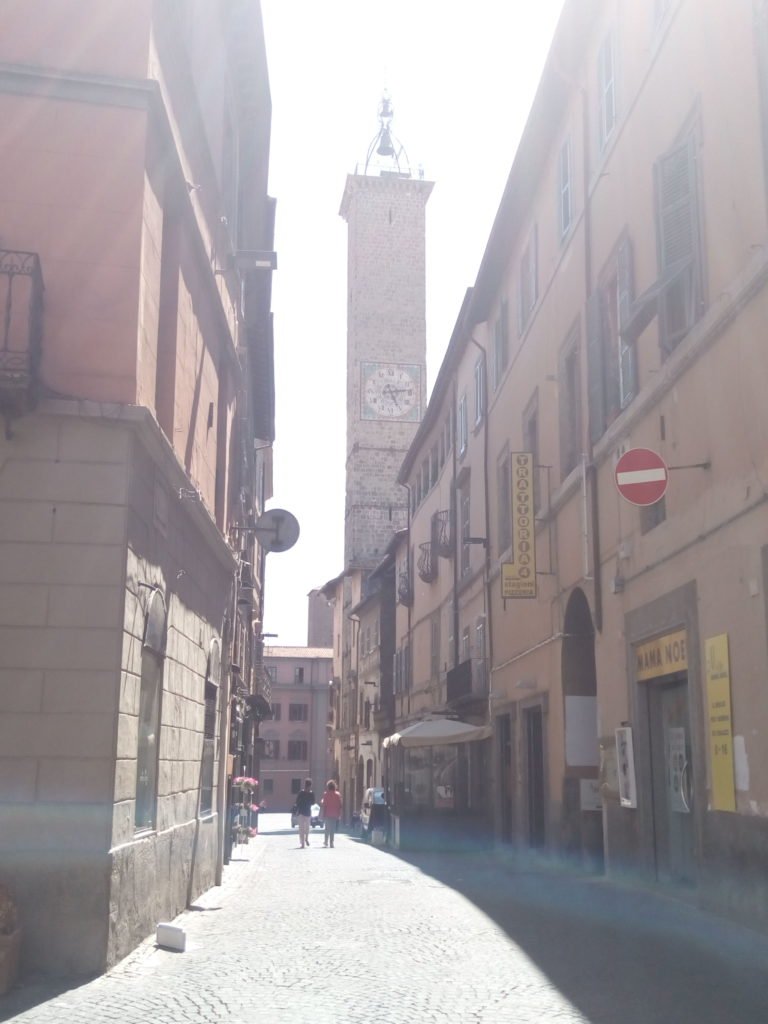 Una calle de Viterbo, con torre con reloj al fondo